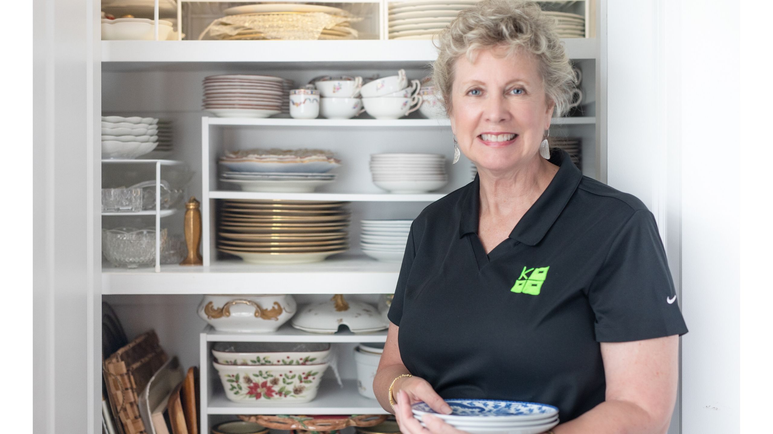 Kris Duderstadt standing in front of organized china cabinet 